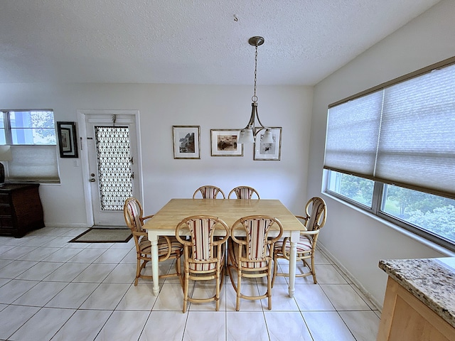 dining room featuring plenty of natural light, a textured ceiling, and light tile patterned flooring