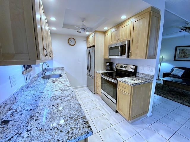 kitchen with sink, stainless steel appliances, a raised ceiling, and light brown cabinets