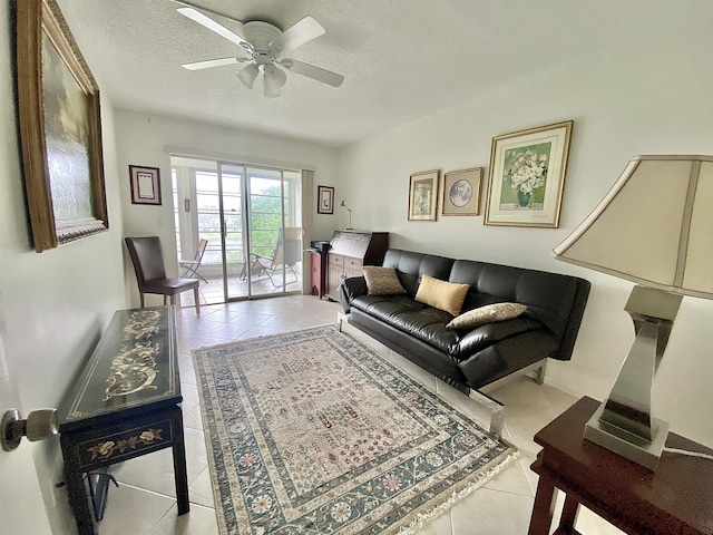 tiled living area featuring a ceiling fan and a textured ceiling