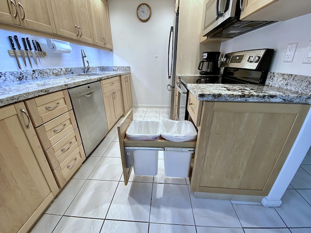 kitchen with stainless steel appliances, light stone countertops, sink, and light brown cabinets