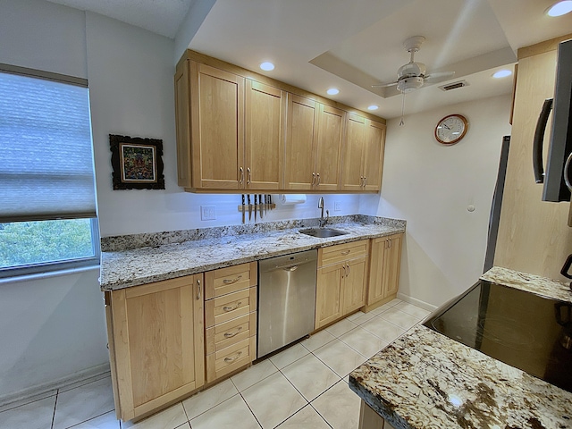 kitchen with a raised ceiling, dishwasher, sink, and light brown cabinetry