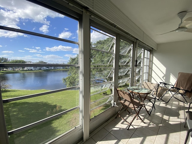 sunroom with a water view and ceiling fan