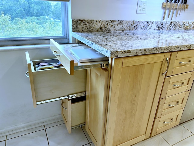 kitchen with light stone counters, light tile patterned floors, and light brown cabinetry