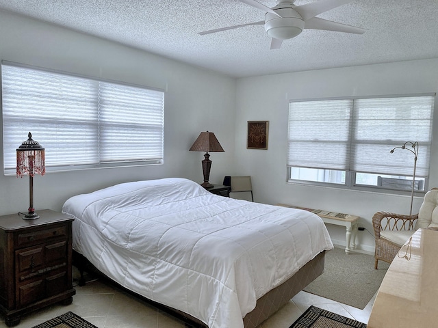 tiled bedroom featuring a textured ceiling and ceiling fan