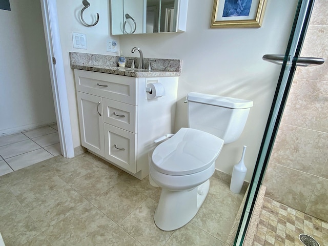 bathroom with a shower, vanity, tile patterned floors, and toilet