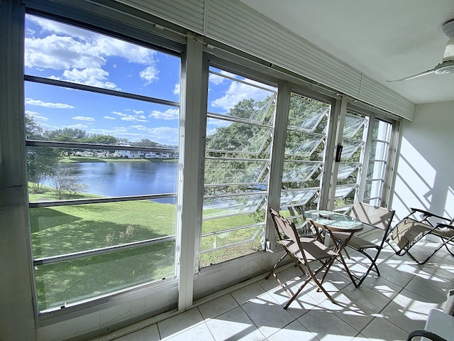 unfurnished sunroom with a water view, plenty of natural light, and ceiling fan