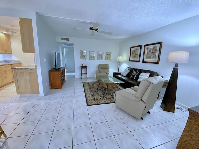 tiled living room featuring ceiling fan and a textured ceiling