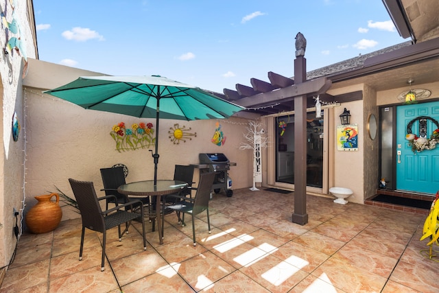 view of patio with area for grilling and a pergola