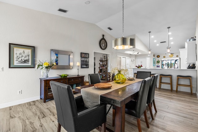 dining area featuring high vaulted ceiling and light wood-type flooring