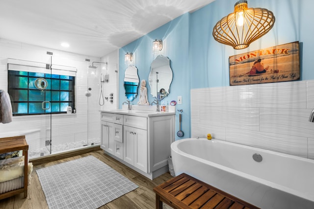 bathroom with vanity, shower with separate bathtub, and wood-type flooring