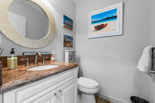 bathroom featuring vanity, toilet, and hardwood / wood-style floors