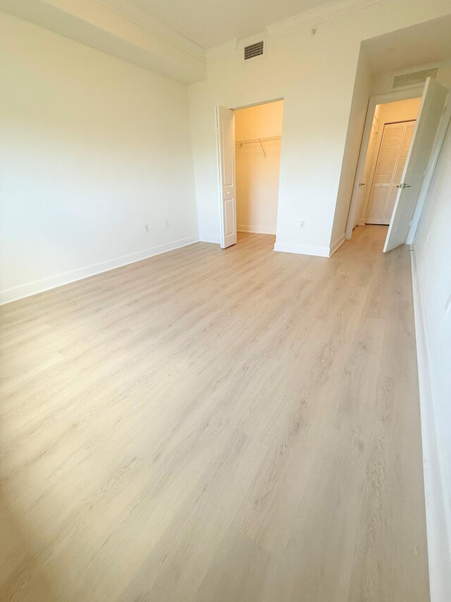 unfurnished living room featuring ornamental molding, light carpet, and a chandelier