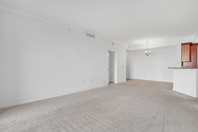 unfurnished living room featuring ornamental molding, a chandelier, and carpet