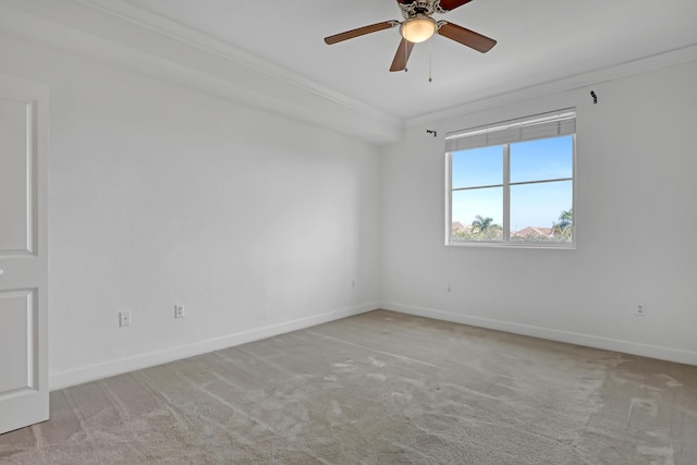 empty room featuring crown molding, light colored carpet, and ceiling fan