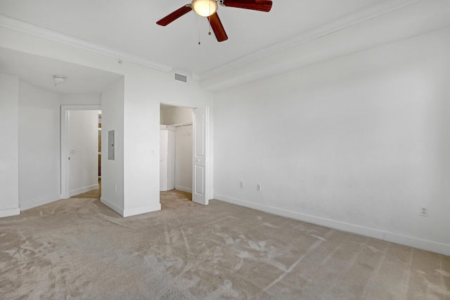 unfurnished bedroom featuring ceiling fan, ornamental molding, electric panel, and light carpet