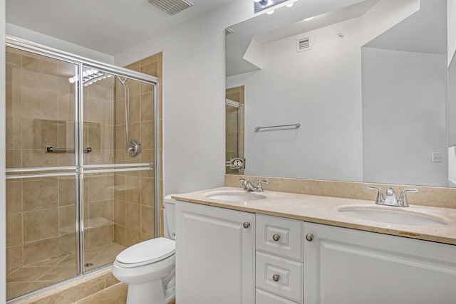 bathroom with an enclosed shower, vanity, tile patterned floors, and toilet