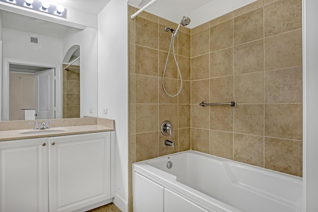 bathroom featuring tiled shower / bath combo and vanity