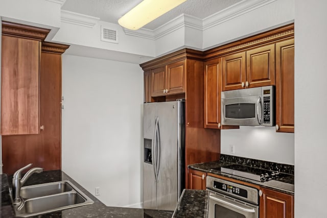 kitchen featuring appliances with stainless steel finishes, sink, dark stone counters, crown molding, and a textured ceiling