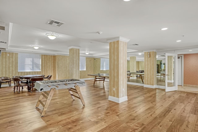 recreation room with crown molding, light hardwood / wood-style floors, and ornate columns