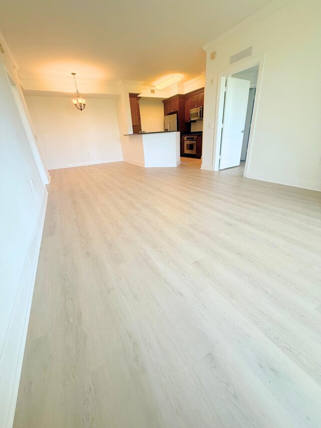 carpeted empty room with an inviting chandelier and crown molding