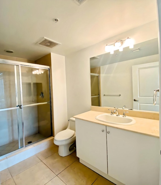 bathroom with a shower with door, vanity, tile patterned floors, and toilet