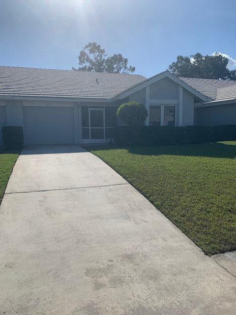 ranch-style home with a garage and a front yard