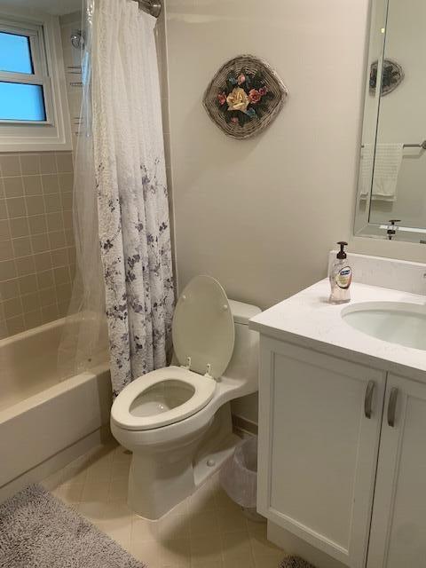 full bathroom with vanity, shower / tub combo, tile patterned floors, and toilet