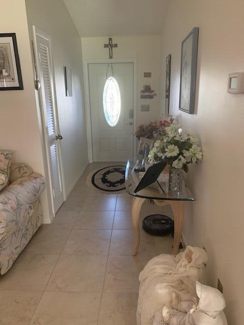 foyer entrance featuring light tile patterned flooring and vaulted ceiling