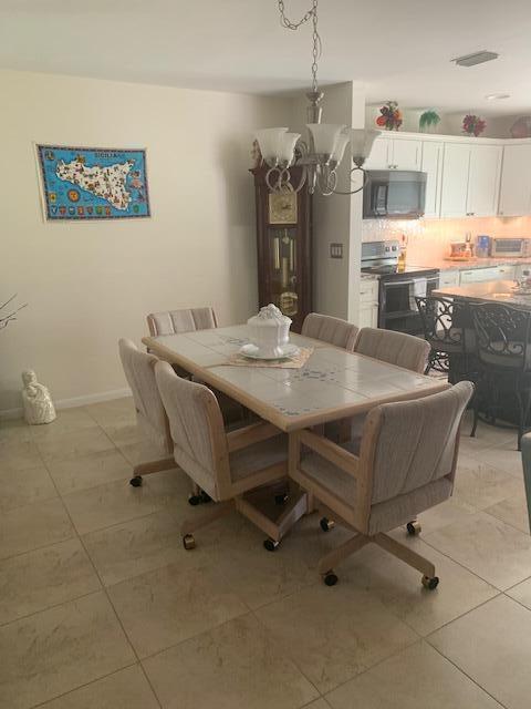 tiled dining area featuring an inviting chandelier