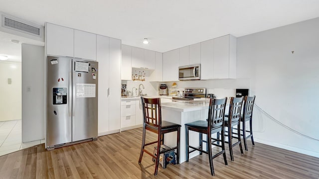 dining space featuring sink and light hardwood / wood-style flooring