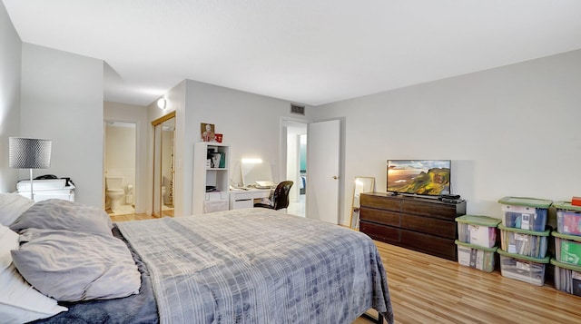 bedroom with ensuite bathroom and light wood-type flooring