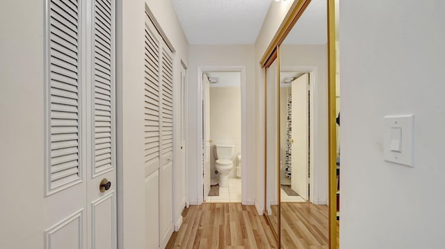 hallway featuring a textured ceiling and light hardwood / wood-style floors