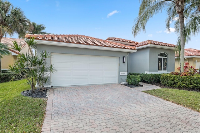 mediterranean / spanish-style home featuring a garage and a front lawn