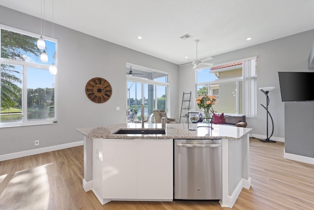 kitchen with light stone countertops, stainless steel dishwasher, white cabinets, and decorative light fixtures