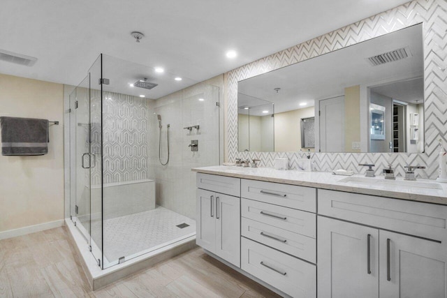 bathroom featuring walk in shower, vanity, hardwood / wood-style flooring, and backsplash