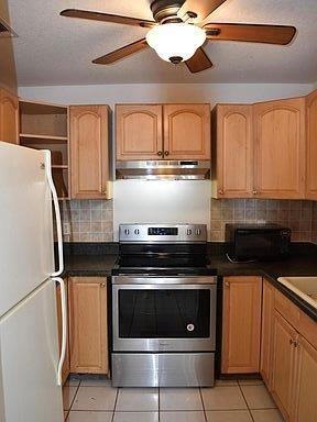 kitchen featuring tasteful backsplash, light tile patterned floors, white refrigerator, electric stove, and ceiling fan