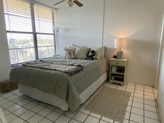 tiled bedroom featuring ceiling fan