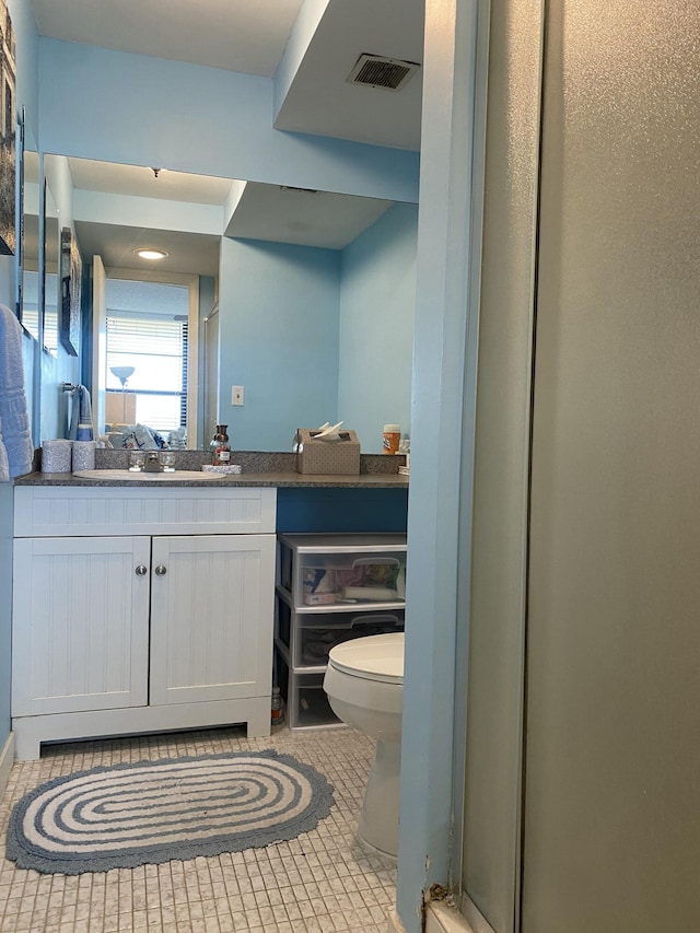 bathroom featuring tile patterned flooring, vanity, and toilet