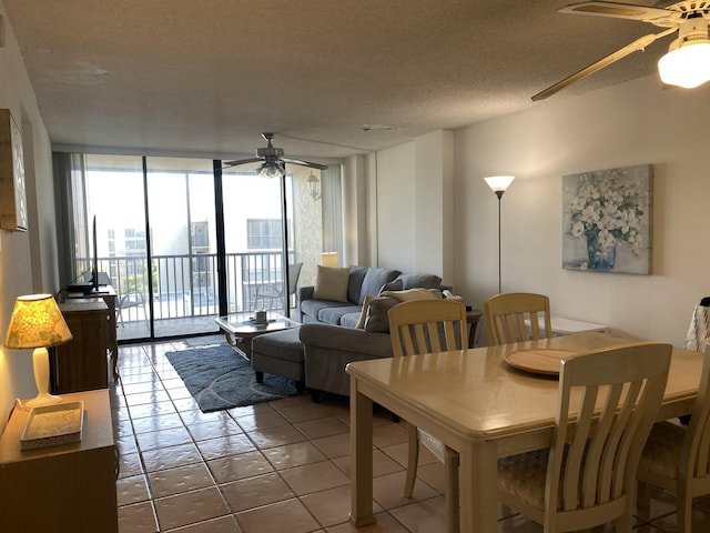 dining area with expansive windows, ceiling fan, tile patterned flooring, and a textured ceiling