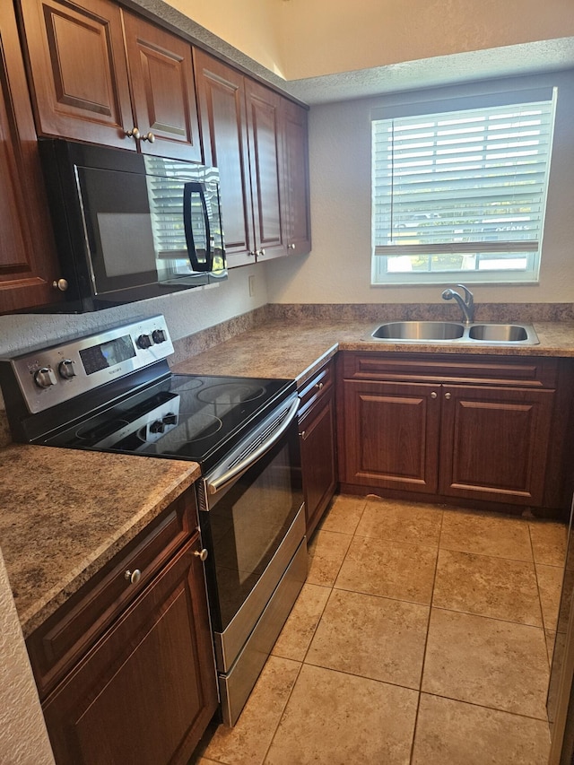 kitchen featuring light tile patterned floors, sink, and electric range