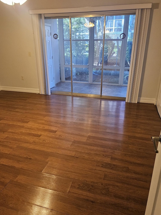 unfurnished room with dark wood-type flooring