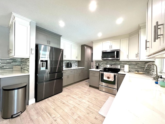 kitchen with white cabinetry, sink, gray cabinets, and stainless steel appliances