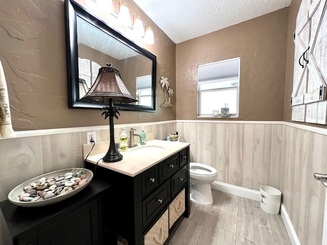 bathroom with vanity, hardwood / wood-style floors, toilet, and a textured ceiling