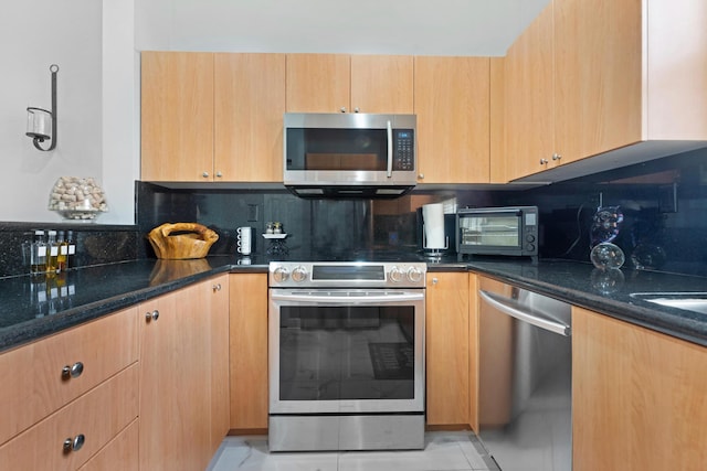 kitchen featuring tasteful backsplash, stainless steel appliances, and dark stone counters