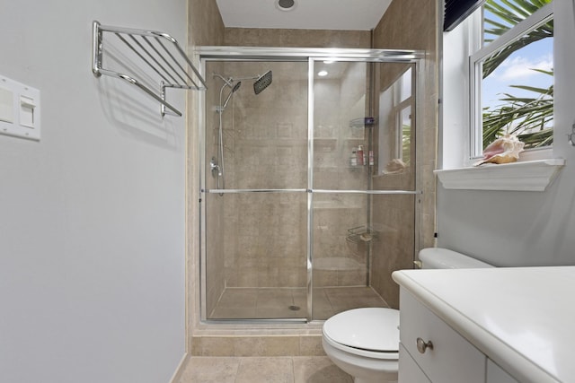 bathroom with tile patterned floors, vanity, toilet, and an enclosed shower