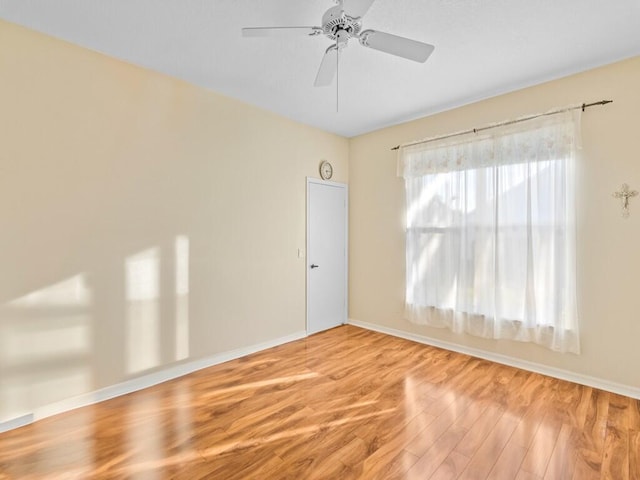 spare room with a ceiling fan, baseboards, and wood finished floors