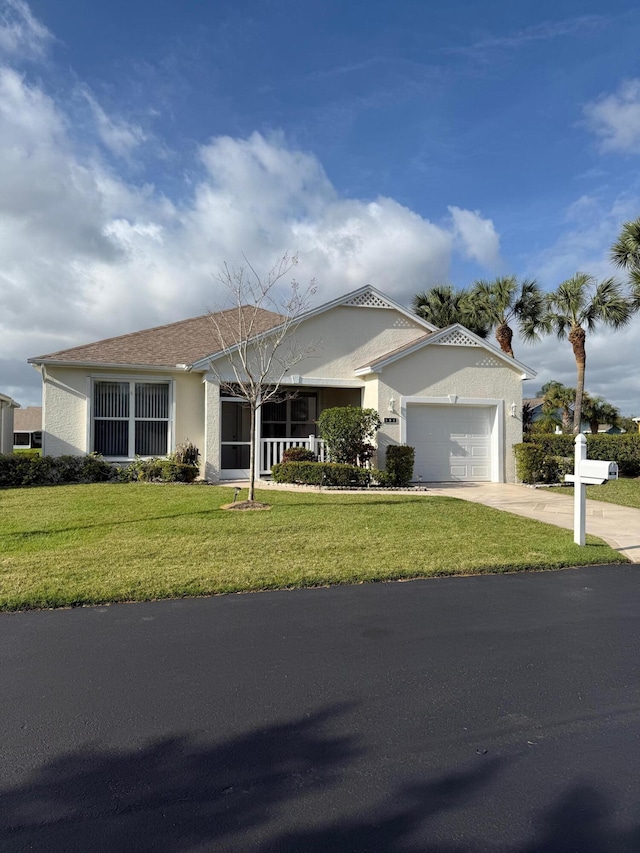 ranch-style home with driveway, a front lawn, an attached garage, and stucco siding