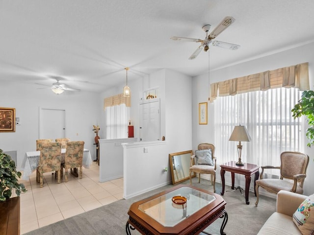 living room with light tile patterned floors, a ceiling fan, and light colored carpet