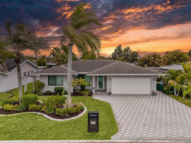 view of front facade with a garage and a lawn