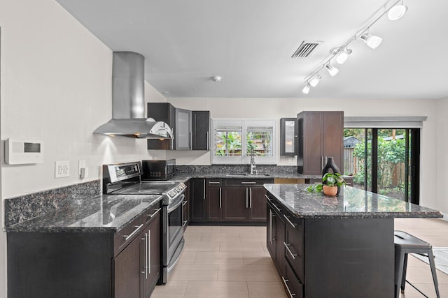 kitchen with electric stove, sink, a kitchen island, island range hood, and a kitchen bar